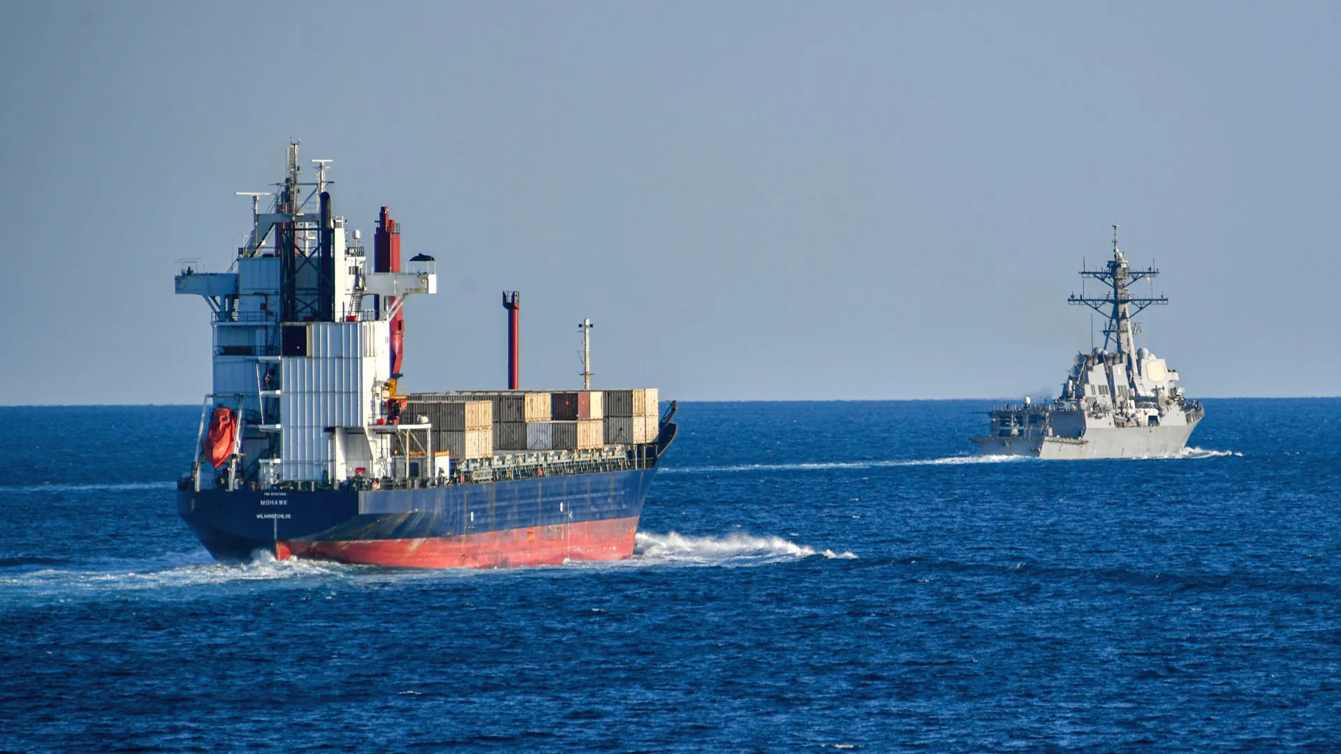 Tanker under naval escort in the Gulf — wide shot