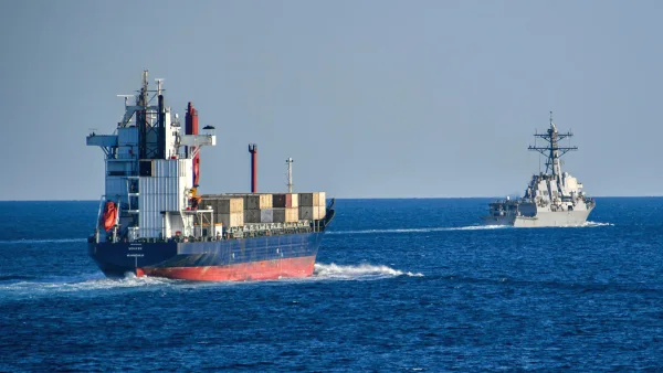 A container ship and a naval vessel at sea