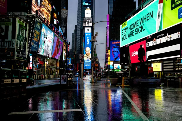 Largely empty Times Square with illuminated billboards