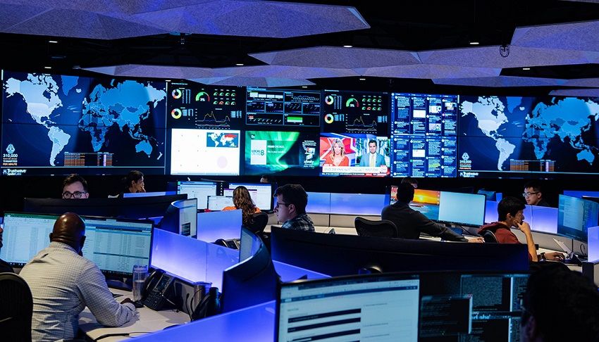 Analysts monitoring cyber risk dashboards in a control room.
