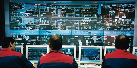 Analysts monitoring cyber risk dashboards in a control room.